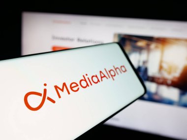 Stuttgart, Almanya - 09-27-2025: İnternet sitesi önünde ekranda müşteri edinme şirketi MediaAlpha Inc. 'in logosuna sahip akıllı telefon. Telefon ekranının soluna odaklan.