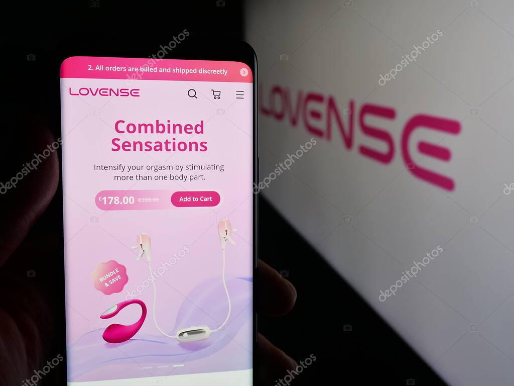 Stuttgart, Germany - 09-25-2025: Person holding smartphone with web page of sex toy company Lovense (Hytto Pte. Ltd.) on screen in front of logo. Focus on center of phone display.