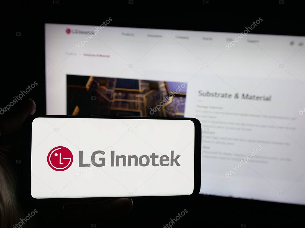 Stuttgart, Germany - 09-25-2025: Person holding smartphone with logo of Korean electronics company LG Innotek Co. Ltd on screen in front of website. Focus on phone display.
