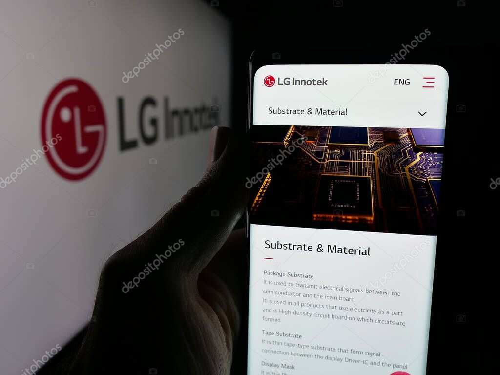 Stuttgart, Germany - 09-25-2025: Person holding smartphone with web page of Korean electronics company LG Innotek Co. Ltd on screen in front of logo. Focus on center of phone display.