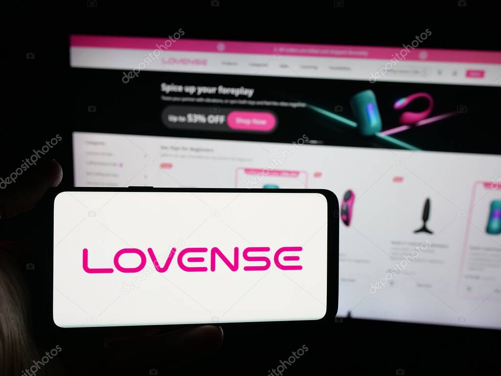 Stuttgart, Germany - 09-25-2025: Person holding smartphone with logo of sex toy company Lovense (Hytto Pte. Ltd.) on screen in front of website. Focus on phone display.