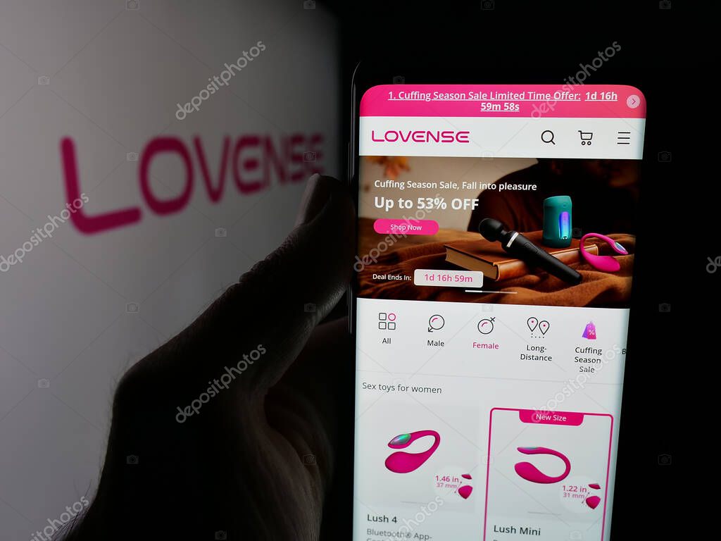 Stuttgart, Germany - 09-25-2025: Person holding cellphone with webpage of sex toy company Lovense (Hytto Pte. Ltd.) on screen in front of logo. Focus on center of phone display.