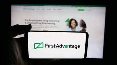 Stuttgart, Almanya - 09-27-2025: ABD geçmiş kontrol şirketinin logosunun bulunduğu cep telefonu sahibi kişi web sayfasının önünde ekranda. Telefon ekranına odaklan.