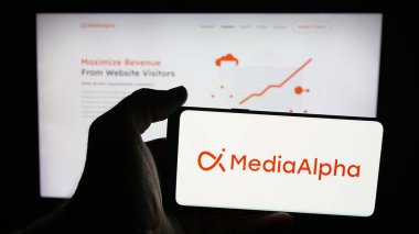 Stuttgart, Almanya - 09-27-2025: Müşteri edinme şirketi MediaAlpha Inc. 'in logosuna sahip cep telefonu web sayfasının önünde ekranda. Telefon ekranına odaklan.