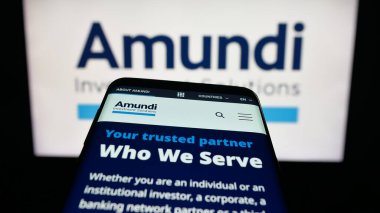 Stuttgart, Almanya - 09-27-2025: Fransız varlık yönetimi şirketi Amundi S.A. 'nın web sitesiyle birlikte cep telefonu logonun önünde ekranda. Telefon ekranının sol üst kısmına odaklan.