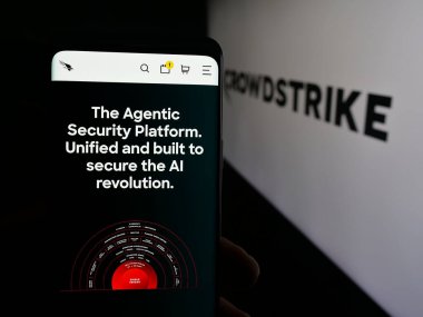 Stuttgart, Almanya - 09-27-2025: Siber güvenlik şirketi CrowdStrike Holding 'in web sitesi ile akıllı telefon sahibi kişi logonun önünde ekranda. Telefon ekranının merkezine odaklan.