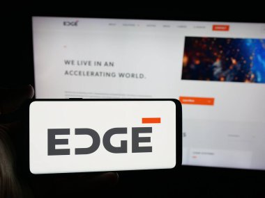 Stuttgart, Almanya - 09-27-2025: Emirati savunma şirketi Edge Group PJSC 'nin logosuna sahip akıllı telefon sahibi kişi web sitesi önünde ekranda. Telefon ekranına odaklan.