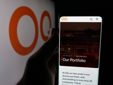 Stuttgart, Almanya - 09-28-2025: Omani petrol şirketi OQ 'nun web sayfası olan cep telefonu logonun önünde ekranda. Telefon ekranının merkezine odaklan.