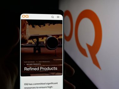 Stuttgart, Almanya - 09-28-2025: Omani petrol şirketi OQ 'nun web sayfasını elinde tutan kişi logonun önünde ekranda. Telefon ekranının merkezine odaklan.