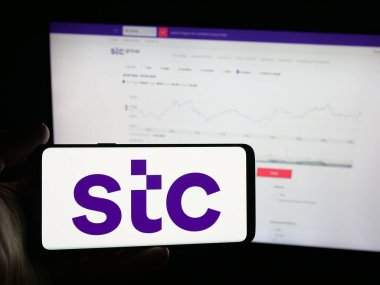 Stuttgart, Almanya - 09-28-2025: Arap iş dünyası Suudi Telekom Şirketi 'nin (STC) logosunu elinde bulunduran kişi web sitesi önünde ekranda. Telefon ekranına odaklan.