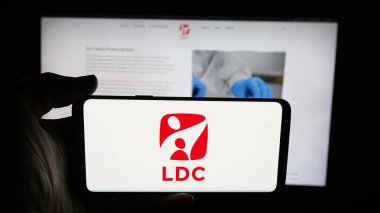 Stuttgart, Almanya - 09-29-2025: Web sayfası önünde Lambert Dodard Chancereul (LDC Group) şirketinin logosunun bulunduğu cep telefonu sahibi kişi. Telefon ekranına odaklan.