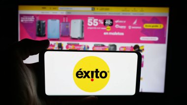 Stuttgart, Almanya - 09-29-2025: Cep telefonunda Kolombiyalı süpermarket şirketi Almacenes Exito 'nun logosu olan kişi web sayfasının önünde ekranda. Telefon ekranına odaklan.