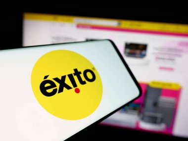 Stuttgart, Almanya - 09-29-2025: Sitenin önünde ekranda Kolombiyalı süpermarket şirketi Almacenes Exito 'nun logosuna sahip akıllı telefon. Telefon ekranının merkez soluna odaklan.
