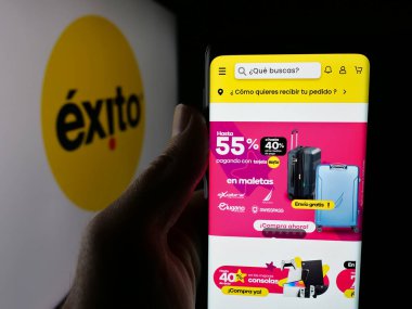 Stuttgart, Almanya - 09-29-2025: Kolombiyalı süpermarket şirketi Almacenes Exito 'nun web sayfası olan cep telefonu logonun önünde ekranda. Telefon ekranının merkezine odaklan.