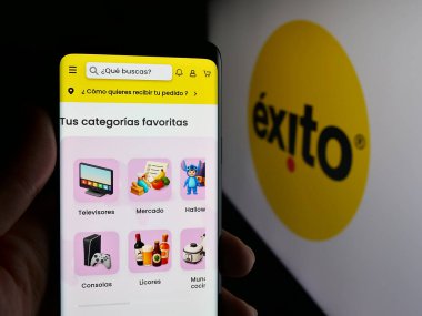 Stuttgart, Almanya - 09-29-2025: Kolombiyalı süpermarket şirketi Almacenes Exito 'nun web sitesi ile akıllı telefon taşıyan kişi logonun önünde ekranda. Telefon ekranının merkezine odaklan.
