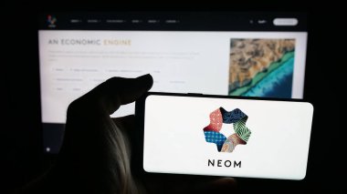Stuttgart, Almanya - 09-29-2025: Suudi Arabistan gayrimenkul projesi NEOM 'un logosunun bulunduğu cep telefonu web sayfasının önünde duruyor. Telefon ekranına odaklan.