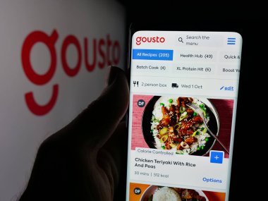 Stuttgart, Almanya - 09-29-2025: Yemek şirketi Gousto 'nun (SCA Investments Limited) web sitesi ile akıllı telefon sahibi kişi logo önünde ekranda. Telefon ekranının merkezine odaklan.