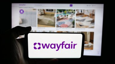 Stuttgart, Almanya - 09-29-2025: Web sayfası önünde ekranda ABD 'li e-ticaret şirketi Wayfair Inc.' in logosunun bulunduğu cep telefonu sahibi kişi. Telefon ekranına odaklan.