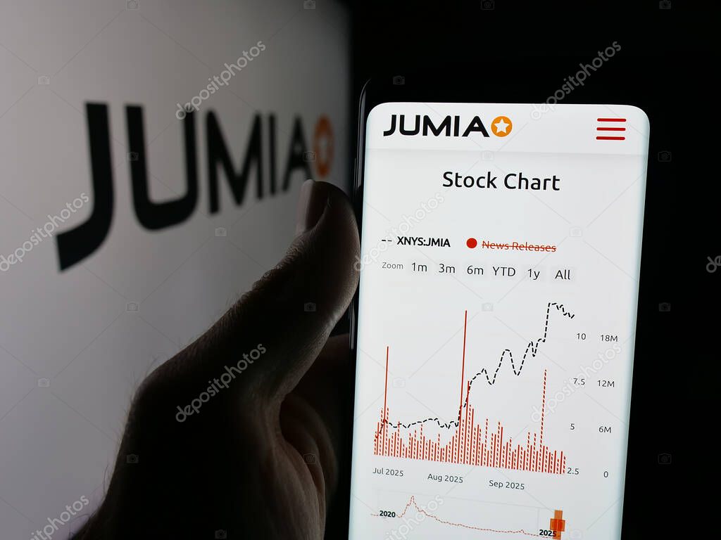 Stuttgart, Germany - 09-29-2025: Person holding cellphone with webpage of e-commerce company Jumia Technologies AG on screen in front of logo. Focus on center of phone display.