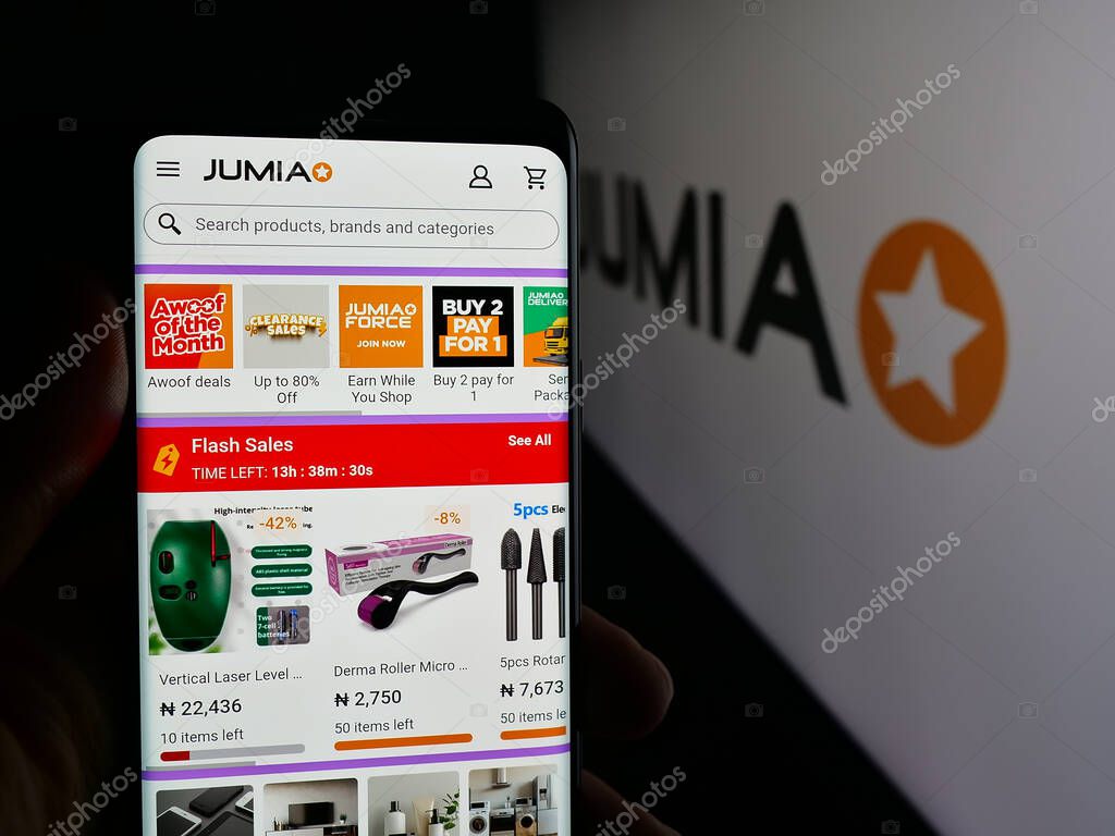 Stuttgart, Germany - 09-29-2025: Person holding smartphone with web page of e-commerce company Jumia Technologies AG on screen in front of logo. Focus on center of phone display.