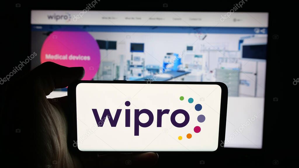 Stuttgart, Germany - 09-29-2025: Person holding cellphone with logo of Indian technology company Wipro Limited on screen in front of webpage. Focus on phone display.