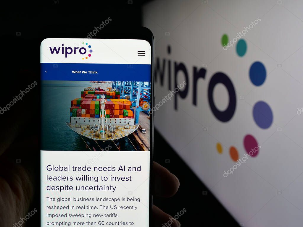 Stuttgart, Germany - 09-29-2025: Person holding smartphone with web page of Indian technology company Wipro Limited on screen in front of logo. Focus on center of phone display.
