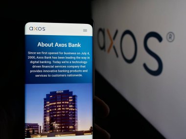 Stuttgart, Almanya - 10-04-2025: ABD 'li bankacılık şirketi Axos Financial Inc.' in web sayfası olan cep telefonu logonun önünde ekranda. Telefon ekranının merkezine odaklan.