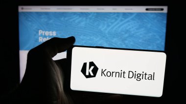 Stuttgart, Almanya - 10-04-2025: İnternet sayfasının önünde ekranda Kornit Dijital Ltd. 'nin logosu olan cep telefonu sahibi kişi. Telefon ekranına odaklan.