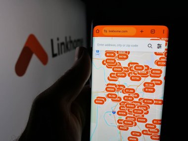 Stuttgart, Almanya - 10-04-2025: ABD 'li emlak şirketi Linkhome Holding Inc.' in web sitesi ile cep telefonu tutan kişi logo önünde ekranda. Telefon ekranının merkezine odaklan.