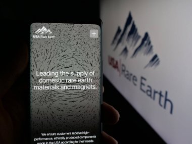 Stuttgart, Almanya - 10-04-2025: ABD 'li maden şirketi USA Rare Earth Inc.' in web sayfası ile akıllı telefon sahibi kişi logonun önünde ekranda. Telefon ekranının merkezine odaklan.