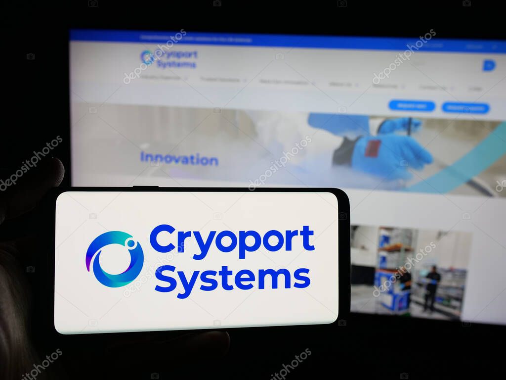 Stuttgart, Germany - 10-04-2025: Person holding smartphone with logo of US supply chain company Cryoport Inc. on screen in front of website. Focus on phone display.