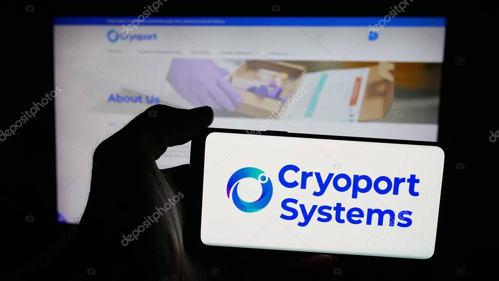 Stuttgart, Germany - 10-04-2025: Person holding mobile phone with logo of US supply chain company Cryoport Inc. on screen in front of web page. Focus on phone display.