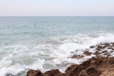 Deniz kıyısındaki Kayalıklara ve Mercan Kayalıklarına Süzülen Dalgalar