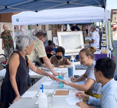 Honolulu, Hawaii, 8 Ekim 2022 - Çin Mahallesi Sanat Gösterisi - Sanatçı eğitmenleri misafirlere resim yapmayı öğretiyor.