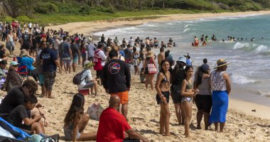 Honolulu, Hawaii, ABD - 2022-08-20 - Shaka Filming Hukilau - Bazıları sahilde durup okyanustan balık ağlarını çekenleri izler.