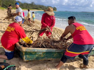 Honolulu, Hawaii, ABD - 2022-08-20 - Shaka Filming Hukilau - İnsanlar balıkçı ağını teknenin dibinde dikkatlice düzenliyor, böylece karışmıyor.