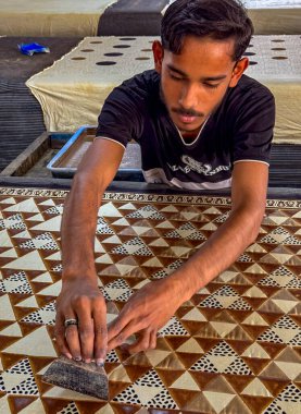 Yetenekli bir zanaatkar, ahşap bir yüzey üzerinde karmaşık kalıplar oluşturmaya odaklanır.