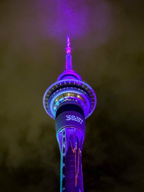 Renkli ışıklar gizemli bir gökyüzünün altındaki ikonik kuleyi süslüyor.