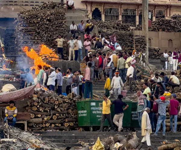 stock image Crowd gathers around a blazing funeral pyre during a traditional indian cremation ceremony