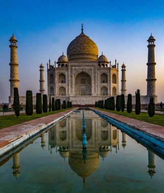 İkonik Tac Mahal, sakin sulara yansıyarak sabahın erken saatlerinde güneşleniyor.