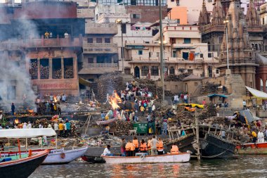 Varanasi ghatlarında hacılar ve teknelerle geleneksel Hindu yakma ayinleri.
