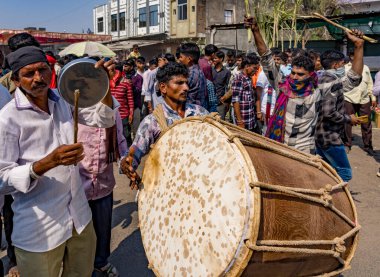 Büyük davullu müzisyenler, şenlikli bir sokak gösterisinde kalabalığa önderlik ediyorlar.