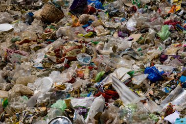 Çöplükte büyük bir çöp yığını ve enkaz birikintisi var.