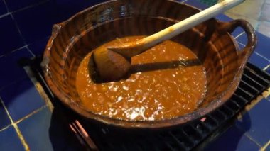 Şef, Meksika, Oaxaca 'daki açık ateşte geleneksel et sosunu karıştırıyor ve zengin mutfak mirası sergiliyor.