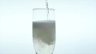 Barmen bardağa köpüklü bir içecek dolduruyor ve beyaz arka planda çilek bırakıyor.