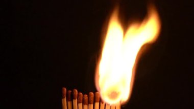 Onbir kibrit çöpü art arda tutuşuyor, canlı renklerle ve yavaş çekimde dinamik hareketlerle büyük bir alev üretiyor.