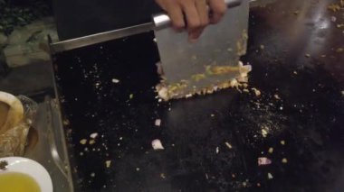 Şef, Sri Lanka restoranındaki bir tabağa kızarmış pirinç ekliyor. Mutfak becerileri ve canlı yerel mutfak yemekleri sergiliyor.