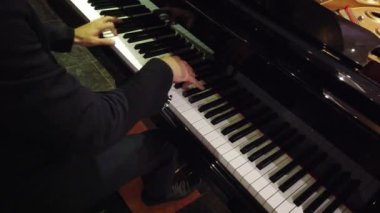 Zarif takım elbiseli bir piyanist siyah bir piyanoda canlı müzik çalar. Geceleri büyüleyici bir atmosfer yaratır.