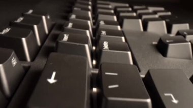 Bilgisayar klavyesi tuşları üzerinde süzülen kamera, modern çalışma alanındaki her anahtarın karmaşık ayrıntılarını ve tasarımını gösterir