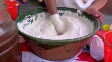 Oaxaca, Meksika 'da bir sokak satıcısı, büyük bir kasede çay hamurunu karıştırıyor, geleneksel mutfak becerilerini sergiliyor.